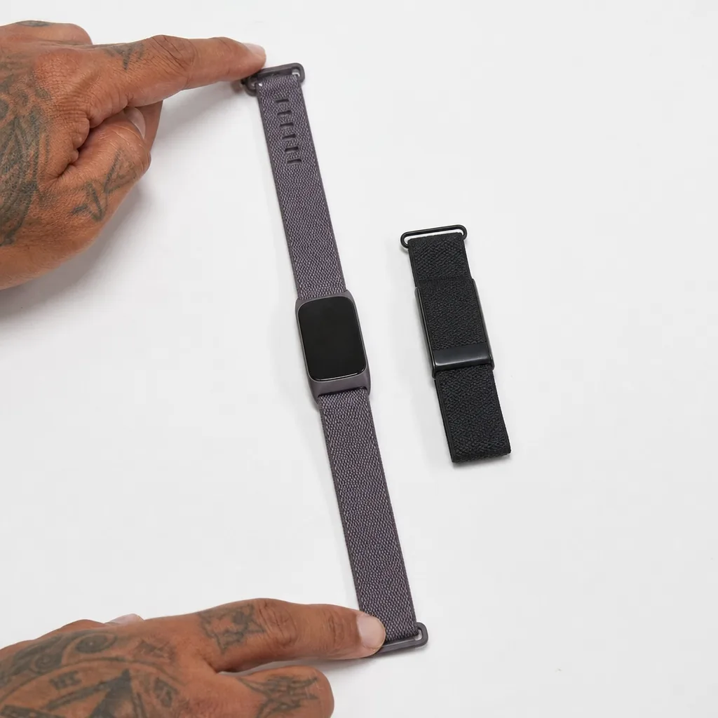 Screenless fitness tracker band on a gym floor beside a water bottle