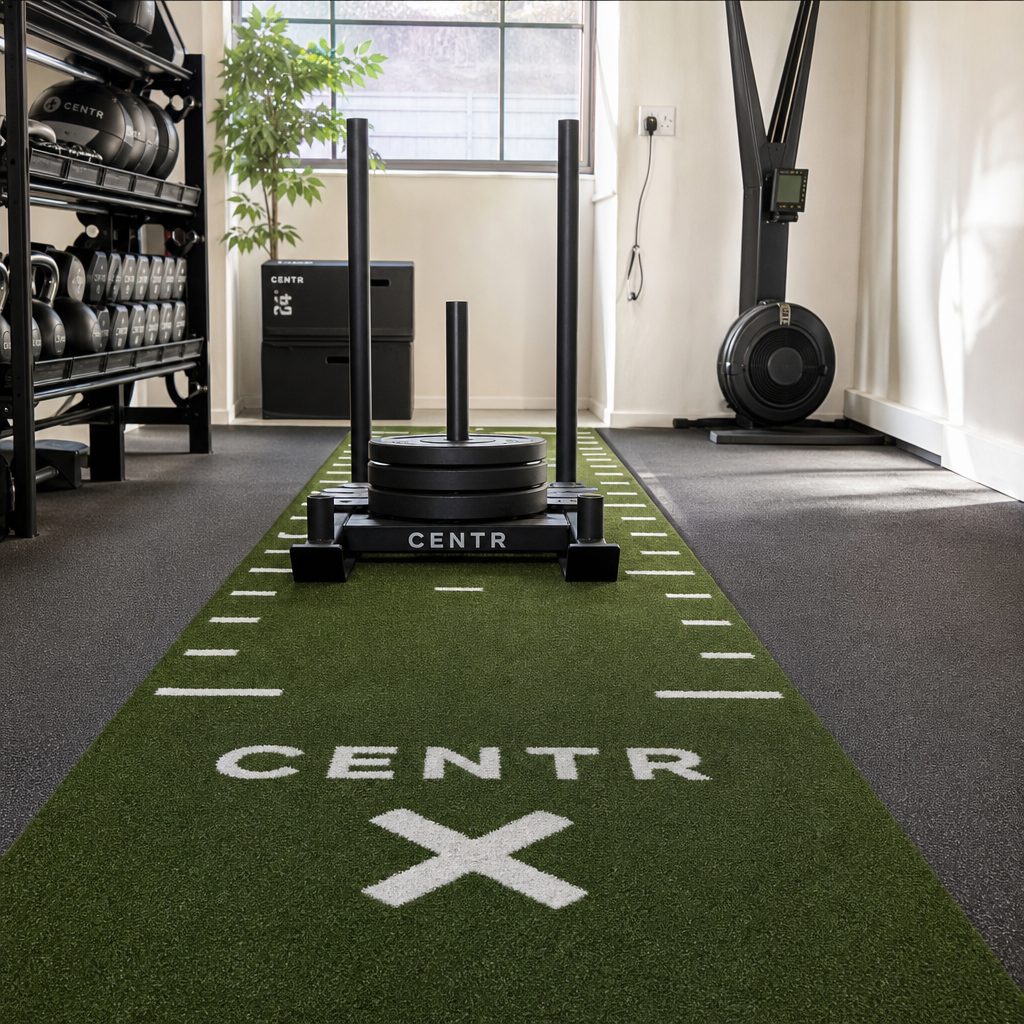 Dense turf with reinforced backing gives a short sled lane a far more consistent feel than an improvised patchwork of loose mats.